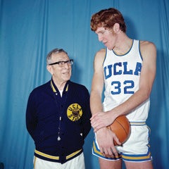 Bill Walton as a young man, towering over coach John Wooden