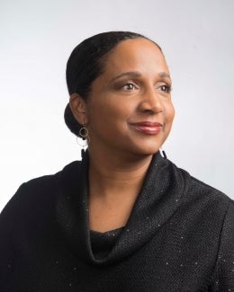 Black woman with hair pulled back, looking off to the side