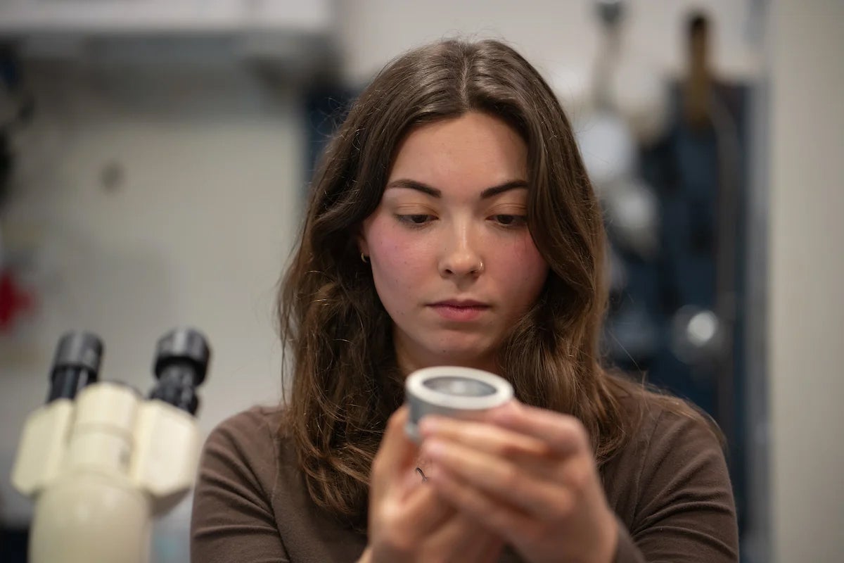 a person holding a jar in a lab