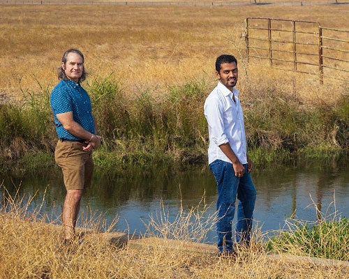 Shawn Newsam and Shrishail Baligar stand on the banks of a slough 