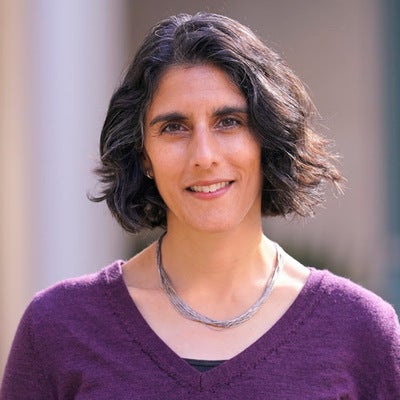 Uma Karmarkar smiles at the camera in a casual headshot