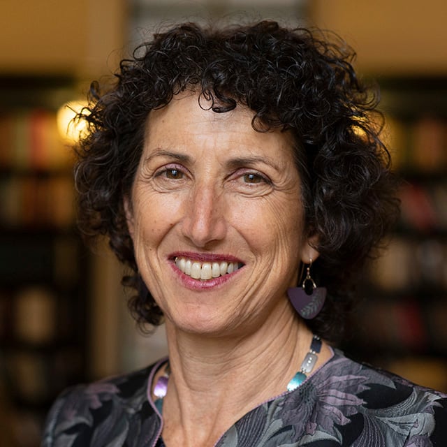 A headshot of a woman with curly hair smiling