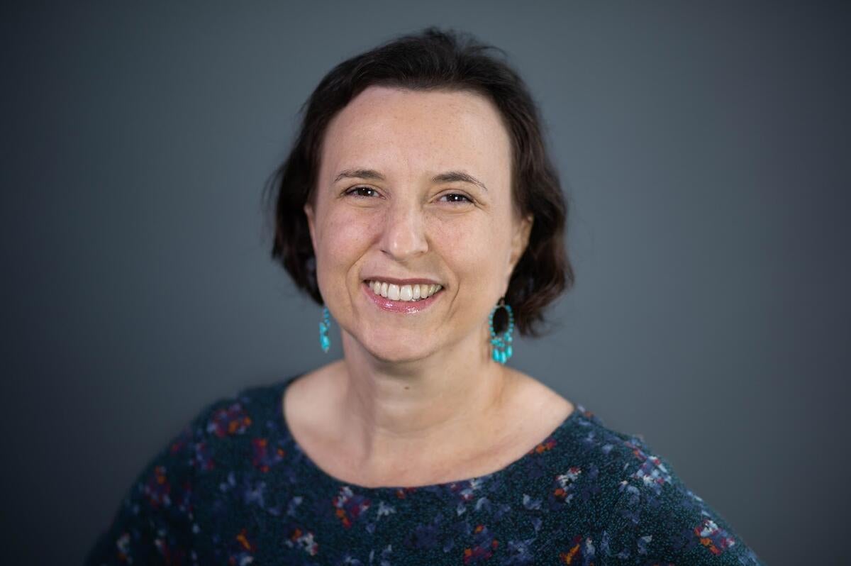 Woman with green earrings smiles