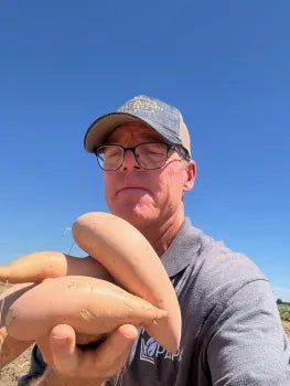 A man holding sweet potatoes