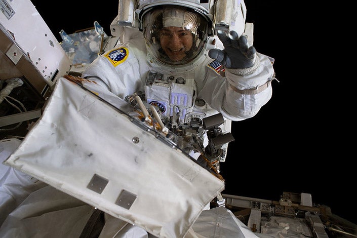 A woman astronaut in space waves