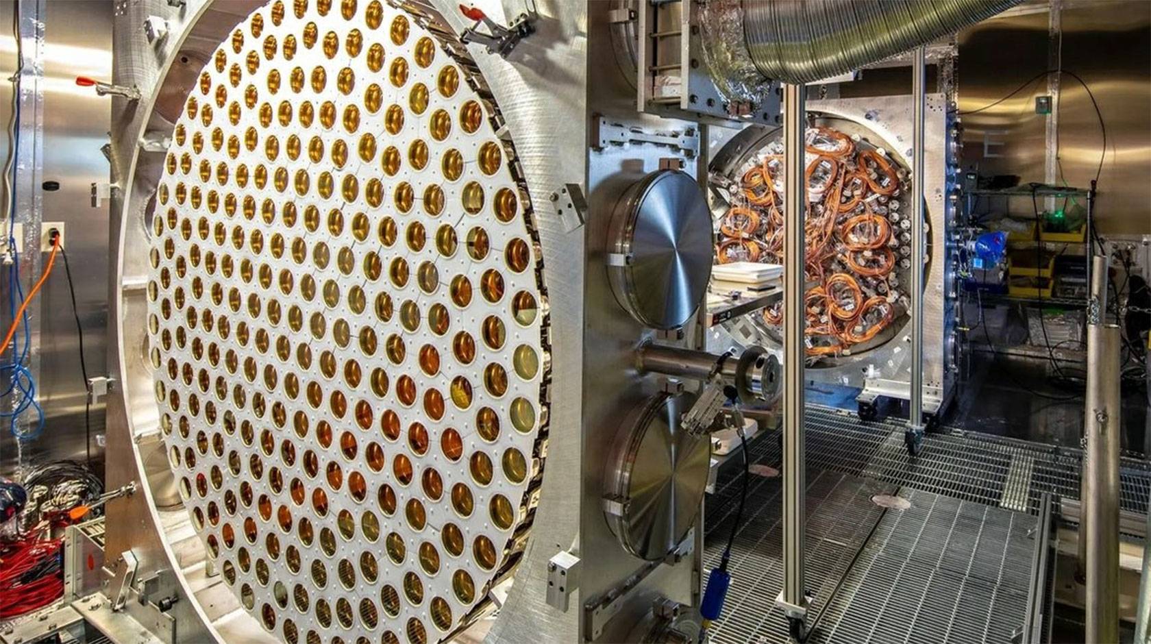 The LUX-ZEPLIN dark matter detector’s instrumentation, including a circular array of gold-toned sensors and wiring inside a clean room.
