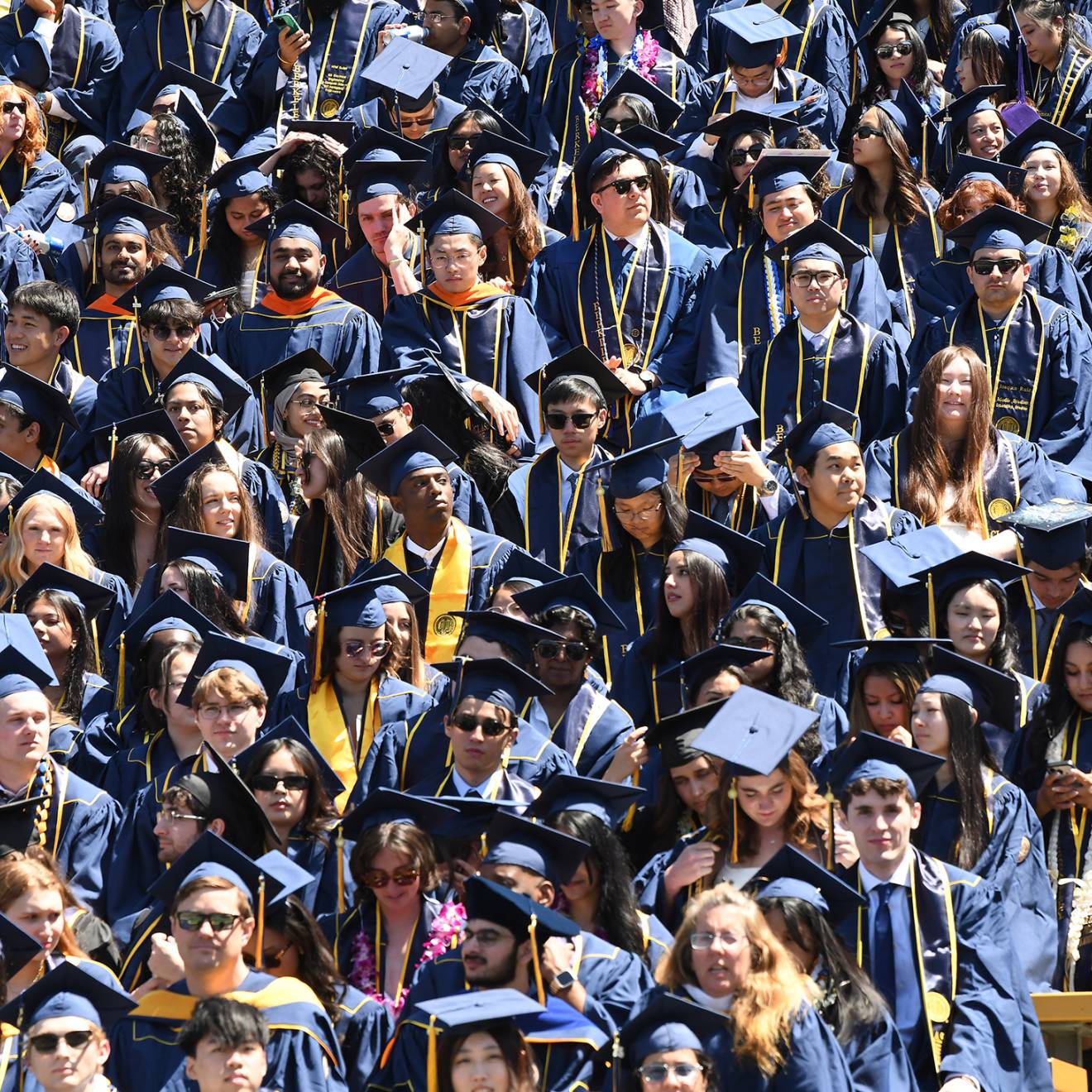 A sea of college students in caps and gowns at graduation